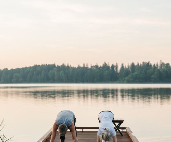 Person stretching calmly outdoors during a beautiful sunrise.
